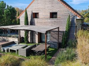 una casa con tavolo da picnic e un grande ombrello di Loft cosy avec piscine et spa, à 10 min de Vichy, proche golf et nature - FR-1-489-337 a Cognat-Lyonne