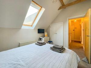 a bedroom with a large white bed with a window at Sea Is All Around in Mundesley
