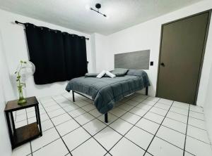 a bedroom with a bed and a black curtain at Departamento amplio y remodelado en Guadalajara in Guadalajara