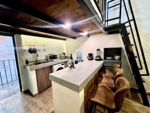 a kitchen with a counter and chairs in a room at Amore e Vino en ValQuirico in Santeagueda