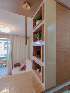 a room with a wall with shelves and a couch at Israel Flat Tambaú - 315 in João Pessoa