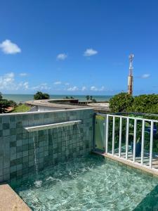 a hot tub on a balcony with the ocean in the background at Israel Flat Tambaú - 315 in João Pessoa