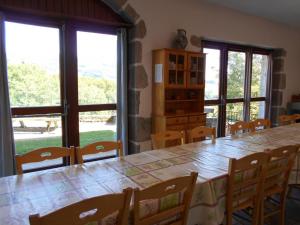 ein Esszimmer mit Tisch und Stühlen und Fenstern in der Unterkunft Gîte familial en montagne, animaux admis, La Chabanne - FR-1-489-343 in La Chabanne