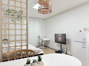 a kitchen and living room with a white refrigerator at Station House Daechi in Seoul
