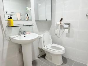 a white bathroom with a toilet and a sink at Station House Daechi in Seoul