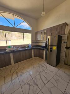an empty kitchen with a refrigerator and a window at House - Quinta Paraíso Mitad del Mundo in San Antonio