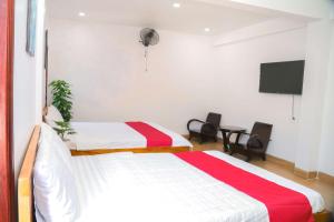 une chambre d'hôtel avec deux lits et une télévision à écran plat dans l'établissement Lucky House, à Hue