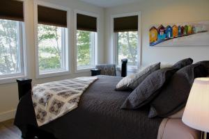 Schlafzimmer mit einem großen Bett und Fenstern in der Unterkunft Whitecaps Retreat Beach House 