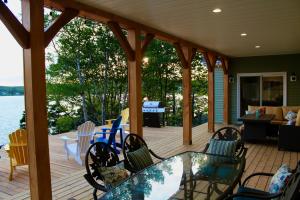 eine abgeschirmte Veranda mit einem Glastisch und Stühlen in der Unterkunft Whitecaps Retreat Beach House 