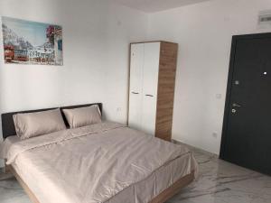 a white bedroom with a bed and a cabinet at Blue Bay Boutique Studio in Đenovići