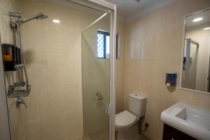 a bathroom with a shower and a toilet and a sink at Novena Palms Motel in Brisbane +14 photos