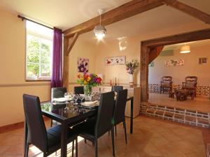 a dining room with a black table and chairs at Maison de charme avec grand jardin, proche Haras du Pin, animaux acceptés, idéale pour familles - FR-1-497-5 in Saint-Pierre-la-Rivière