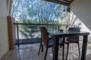 a table and chairs on a balcony with a view at Novena Palms Motel in Brisbane