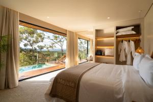 a bedroom with a bed and a large window with a pool at Majulê Ecolodge in Cavalcante +27 photos