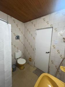 a bathroom with a toilet and a sink and a door at Casa de chacra in Veinticinco de Mayo +6 photos