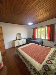 a bedroom with two beds and a bed and a window at Casa de chacra in Veinticinco de Mayo
