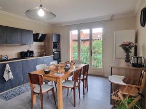 una sala da pranzo con tavolo e sedie in cucina di Gîte spacieux avec terrasse, cheminée, wifi et parking à Roanne - FR-1-496-337 a Roanne Altre 18 foto