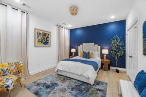 a bedroom with a bed and a blue wall at Downtown Oasis Rooftop with Skyline View in Houston +54 photos