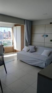 a large bed in a room with a large window at Studio Iracema 2001 in Fortaleza +16 photos