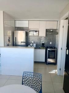 a kitchen with a refrigerator and a stove top oven at Studio Iracema 2001 in Fortaleza