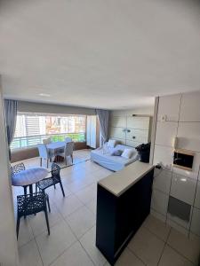 a kitchen and living room with a couch and a table at Studio Iracema 2001 in Fortaleza
