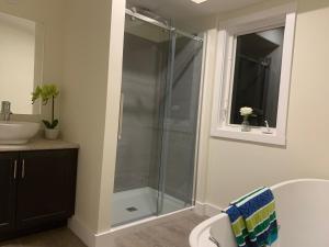 un bagno con doccia in vetro e lavandino di Whitecaps Summit Beach House  Altre 15 foto