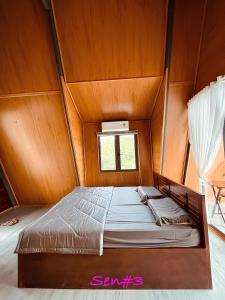 un letto in una stanza con soffitto in legno di Mây's garden camping a Tây Ninh