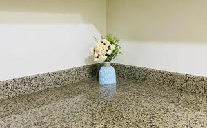 a blue vase with flowers in it sitting on a counter at V-TAN house in Manila +2 photos