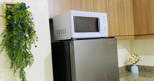 a microwave on top of a refrigerator in a kitchen at V-TAN house in Manila