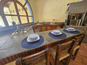 a kitchen with a table with bowls and plates on it at Zihua 6bed 3bath Home for 12 with Direct Access to Beach in Zihuatanejo