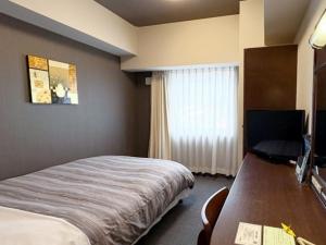 Postel nebo postele na pokoji v ubytování Hotel Route-Inn Utsunomiya Miyukicho -Kokudou4gou-