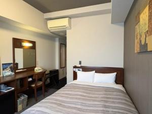 Postel nebo postele na pokoji v ubytování Hotel Route-Inn Utsunomiya Miyukicho -Kokudou4gou-