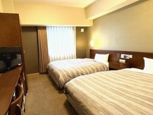 Postel nebo postele na pokoji v ubytování Hotel Route-Inn Utsunomiya Miyukicho -Kokudou4gou-