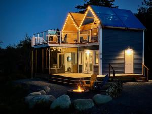a house with a fire pit in front of it at Whitecaps Cabana for Couples in La Have