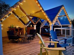 a deck with chairs and a table and lights at Whitecaps Cabana for Couples in La Have