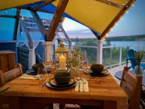 a wooden table with wine glasses and a candle on it at Whitecaps Cabana for Couples in La Have