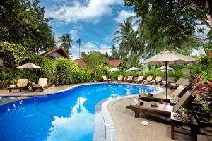 a pool at a resort with chairs and umbrellas at Smile House - Fisherman Village in Bophut