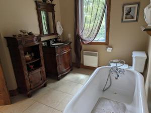 a bathroom with a bath tub and a sink at Eagle Nest Cottage in Val des Monts +34 photos