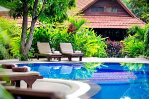 two chairs and a swimming pool in front of a house at Smile House - Fisherman Village in Bophut