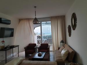 a living room with a couch and a large window at Madame facances in Saïdia