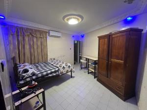 a bedroom with a bed and a desk and a cabinet at Keur kay khol in Saint-Louis