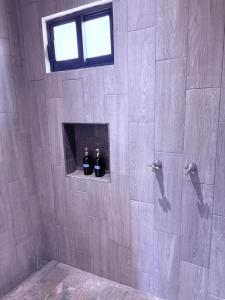 a bathroom with two bottles of wine on a wall at Casa Guaria Morada in Valle de Bravo