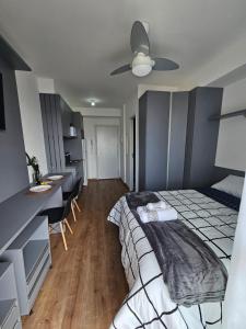 a bedroom with a bed and a desk and a kitchen at zyz centro in Sao Paulo