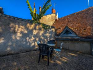 einen Tisch und Stühle neben einem Gebäude in der Unterkunft Maison paisible à Châteauroux avec jardin et parking privé - FR-1-591-759 in Châteauroux