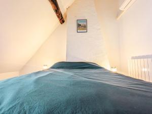 ein Schlafzimmer mit einem blauen Bett in einem Dachgeschoss in der Unterkunft Maison paisible à Châteauroux avec jardin et parking privé - FR-1-591-759 in Châteauroux