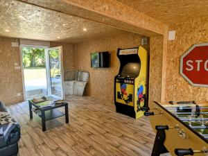 Una sala de estar con una máquina de videojuegos y una señal de stop. en Studio confortable à Vignot, proche Commercy - FR-1-585-182, en Vignot