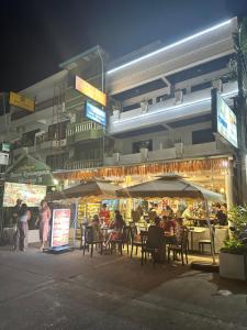 a group of people sitting at a restaurant at night at Istanbul Boutique Hotel in Patong Beach