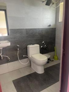 a bathroom with a toilet and a sink at Misty Dawn Villas By Sunset Valley in Ooty