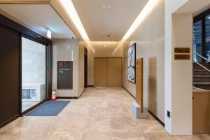 a hallway of a building with a door and a staircase at Aank Ryokan Hotel Songtan in Pyeongtaek