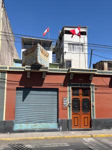 a building on a street with a canadian flag at Hab Simple baño compartido Estudiante o Voluntario terraza vista a los Volcanes in Arequipa